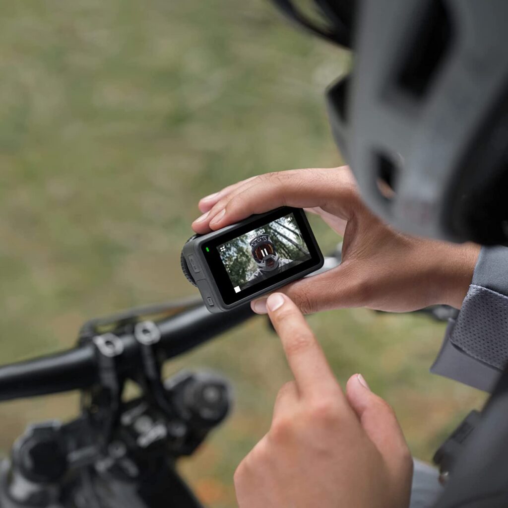 A person holding a DJI Osmo Action 4K camera while riding a bicycle, DJI Osmo Action 3