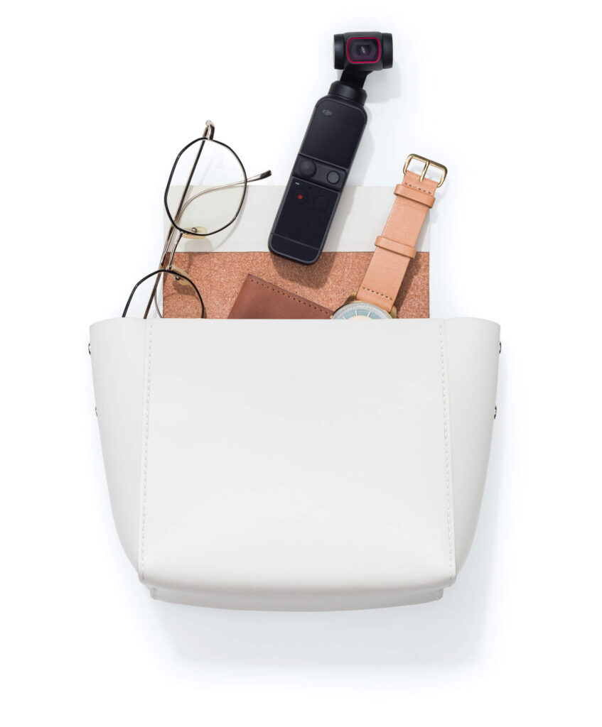White purse with DJI Pocket 2 camera, glasses, watch, and wallet, DJI Pocket 2