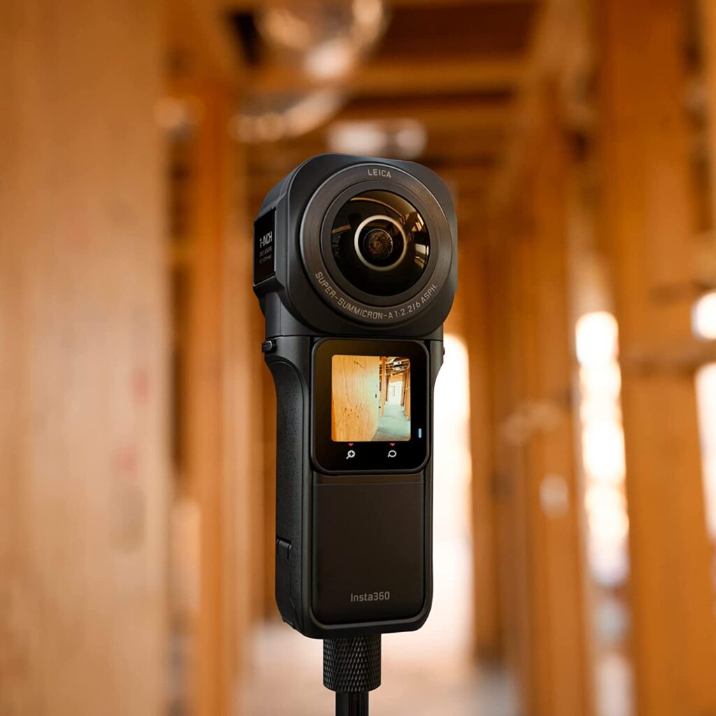 Insta360 ONE RS camera sitting on a tripod in a wooden room, Insta360 ONE RS 1-Inch 360