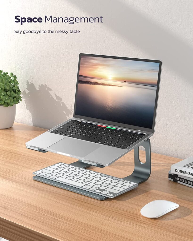 A laptop sitting on a desk next to a keyboard. The laptop is open and the text "Space Management" is visible on the screen. - productcruise.com